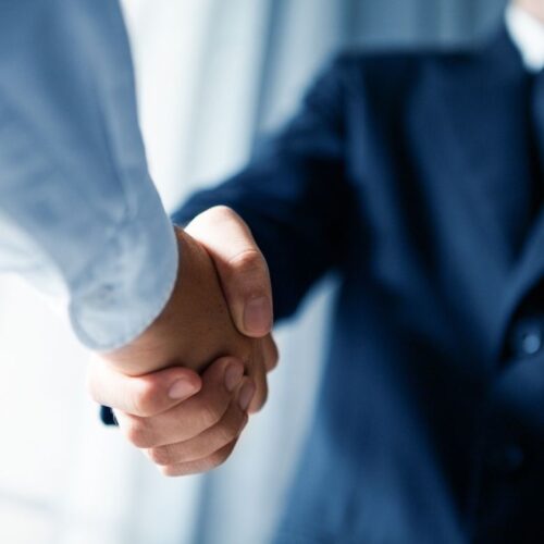 Men wearing suits shaking hands