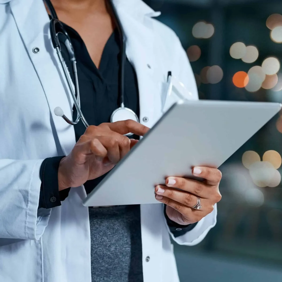 Doctor in white coat holding tablet