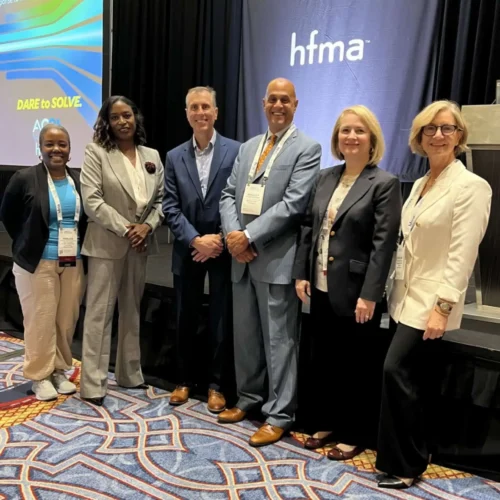 Team of experts standing at a conference with Khalida Burton of Kohler HealthCare Consulting