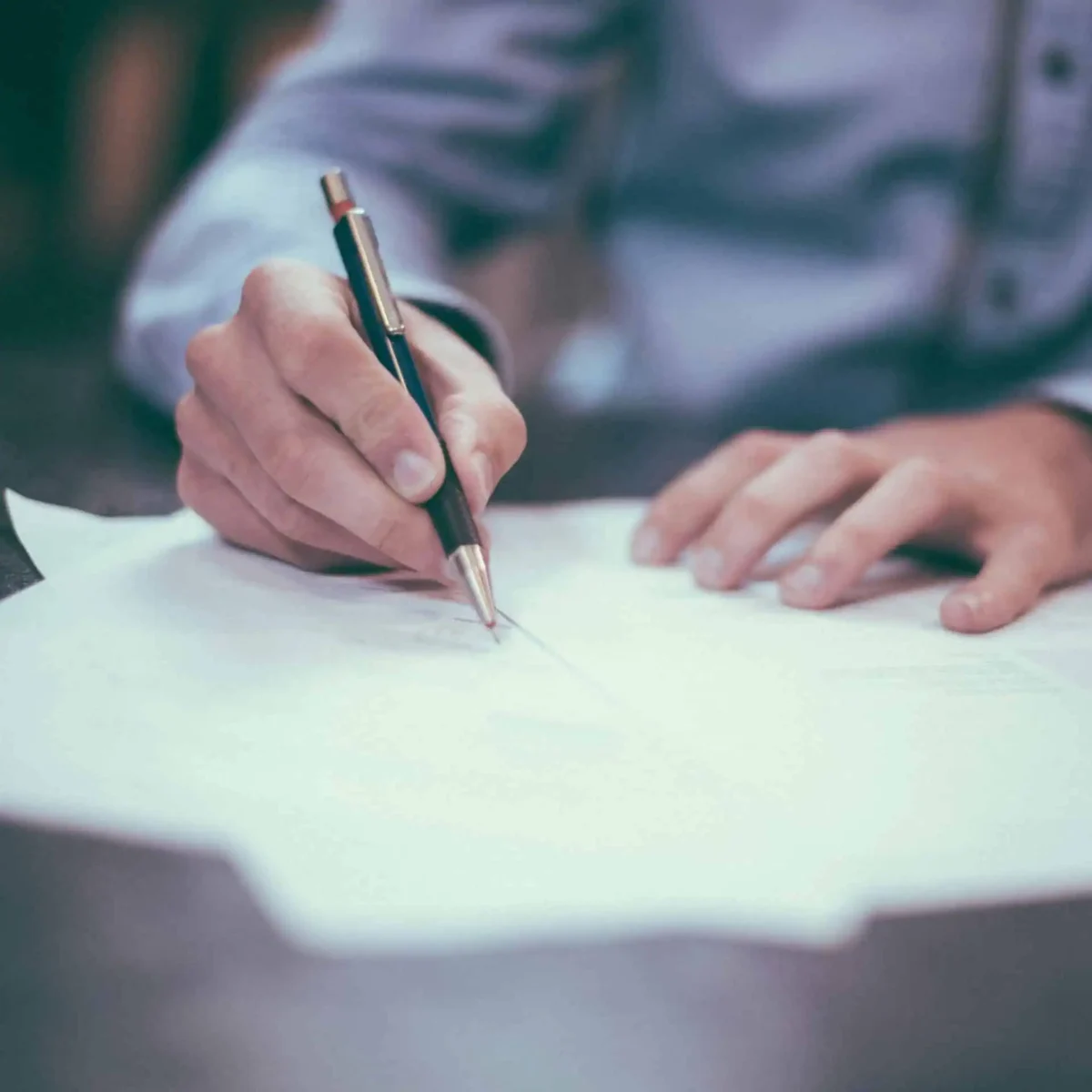 Man writing with pen on legal documents